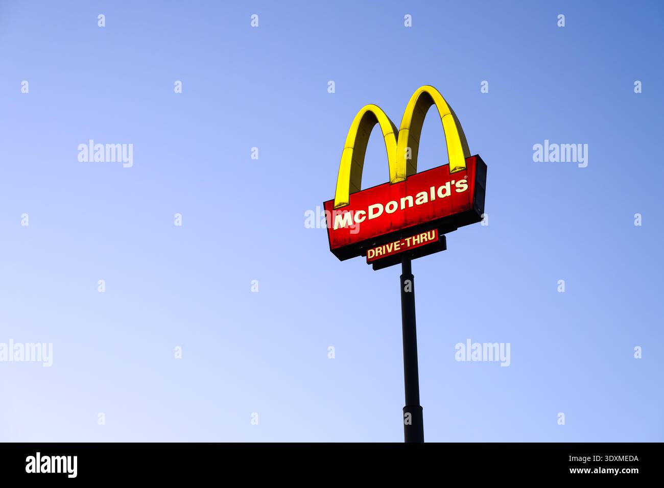 Burlington, WA, États-Unis - 15 février 2026 ; grande enseigne lumineuse avec logo et message au drive-in chez McDonald's contre le ciel bleu de l'aube Banque D'Images