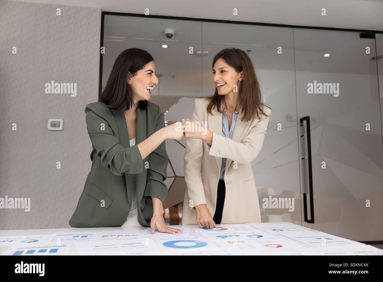 Deux femmes d'affaires heureuses échangeant le premier geste de coup de poing Banque D'Images