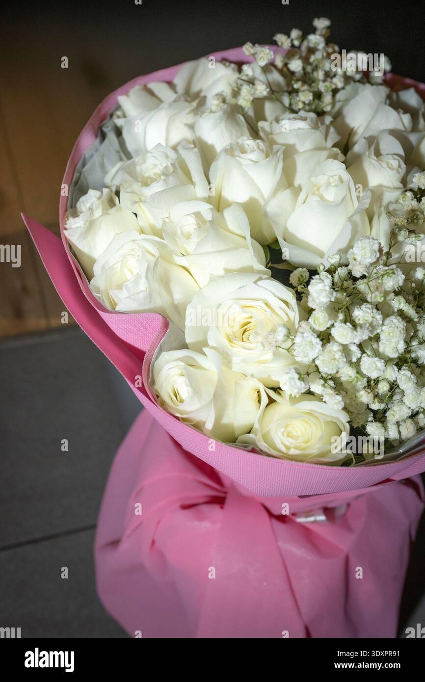 Élégant bouquet de roses blanches avec Gypsophila sur fond sombre Banque D'Images