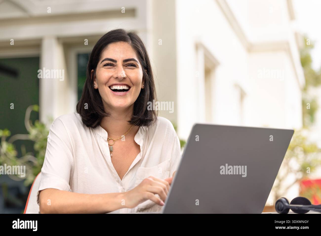 Joyeuse jeune femme hispanique travailleuse à distance assise sur le lieu de travail Banque D'Images