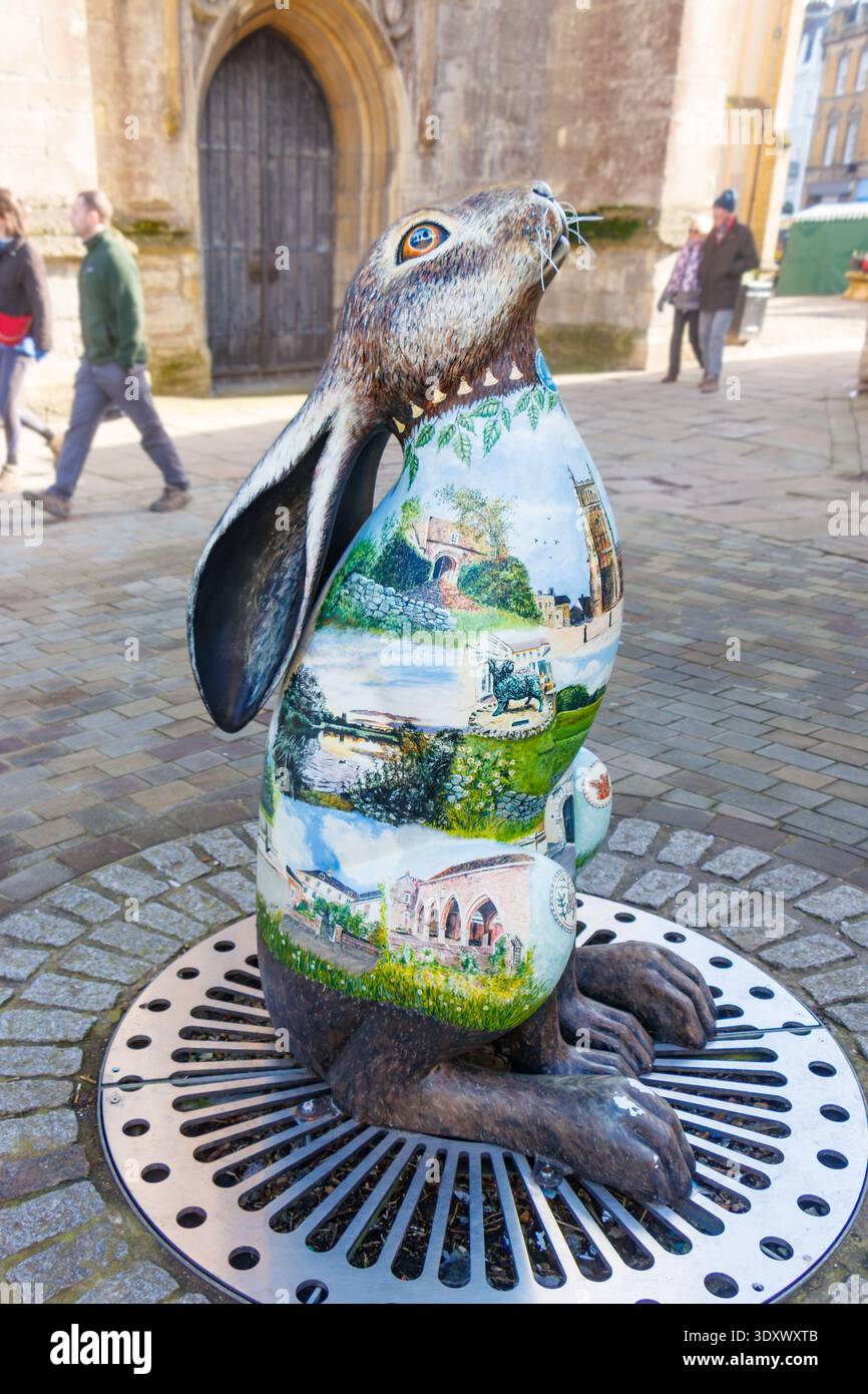 Sculpture de lièvre peinte en fibre de verre 'Horace', une sculpture d'art public commandée par la Cirencester Civic Society avec des paysages détaillés sur son corps Banque D'Images