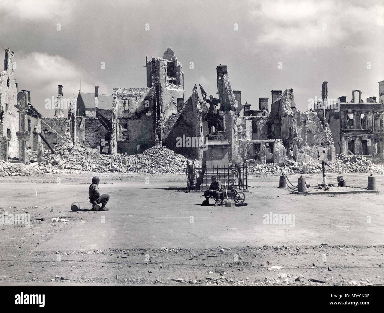 Deux soldats américains dans la ville en ruine de Montebourg en Normandie. Le 6 juin 1944, une énorme force d'invasion Alllied impliquant 7000 navires et 140 000 hommes débarque avec succès sur les côtes françaises et établit cinq têtes de plage. Une campagne de tromperie réussie signifiait qu'une grande partie de la résistance allemande était à Calais et que les pertes étaient relativement peu nombreuses compte tenu de l'ampleur et des dangers de l'opération. Banque D'Images