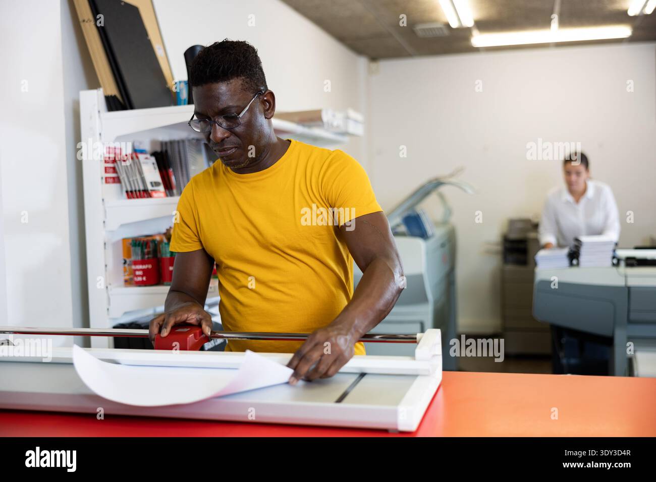 Portrait d'un employé positif de la maison d'impression avec des projets entre les mains Banque D'Images