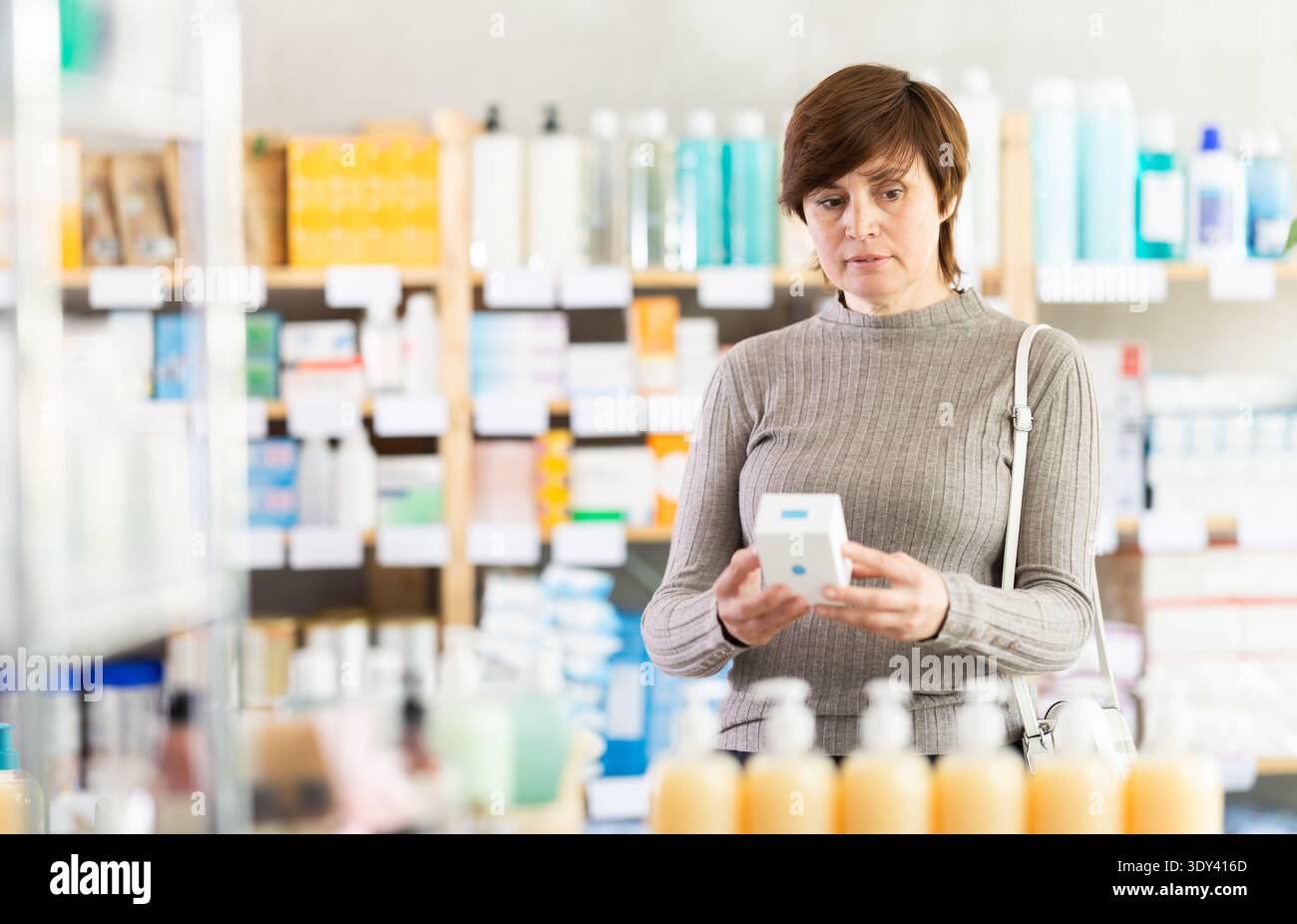 Femme choisissant les médicaments prescrits au comptoir de pharmacie Banque D'Images