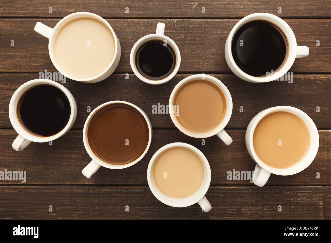 Différents types de café dans des tasses sur une table en bois, vue de dessus Banque D'Images