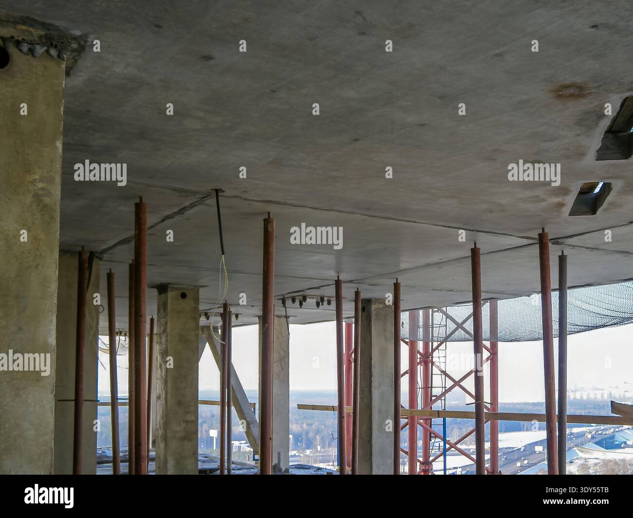Une vue du chantier, montrant un plafond en béton soutenu par des poutres métalliques et des charpentes en bois, prêt pour la phase suivante. Banque D'Images