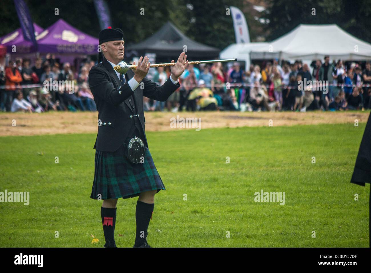 Un tambour-major en tenue traditionnelle des Highlands avec kilt et bonnet à plumes fait tournoyer sa masse lors des jeux des Highlands à Stirling. Banque D'Images