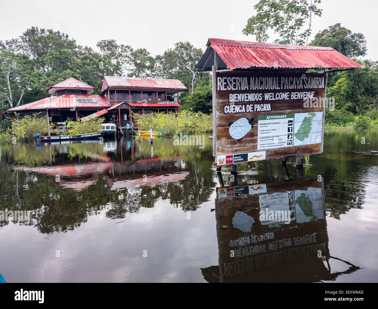 Signalétique de réserve locale près de l'eau à Pacaya Samiria réserve au Pérou avec des bâtiments et de la végétation autour Banque D'Images