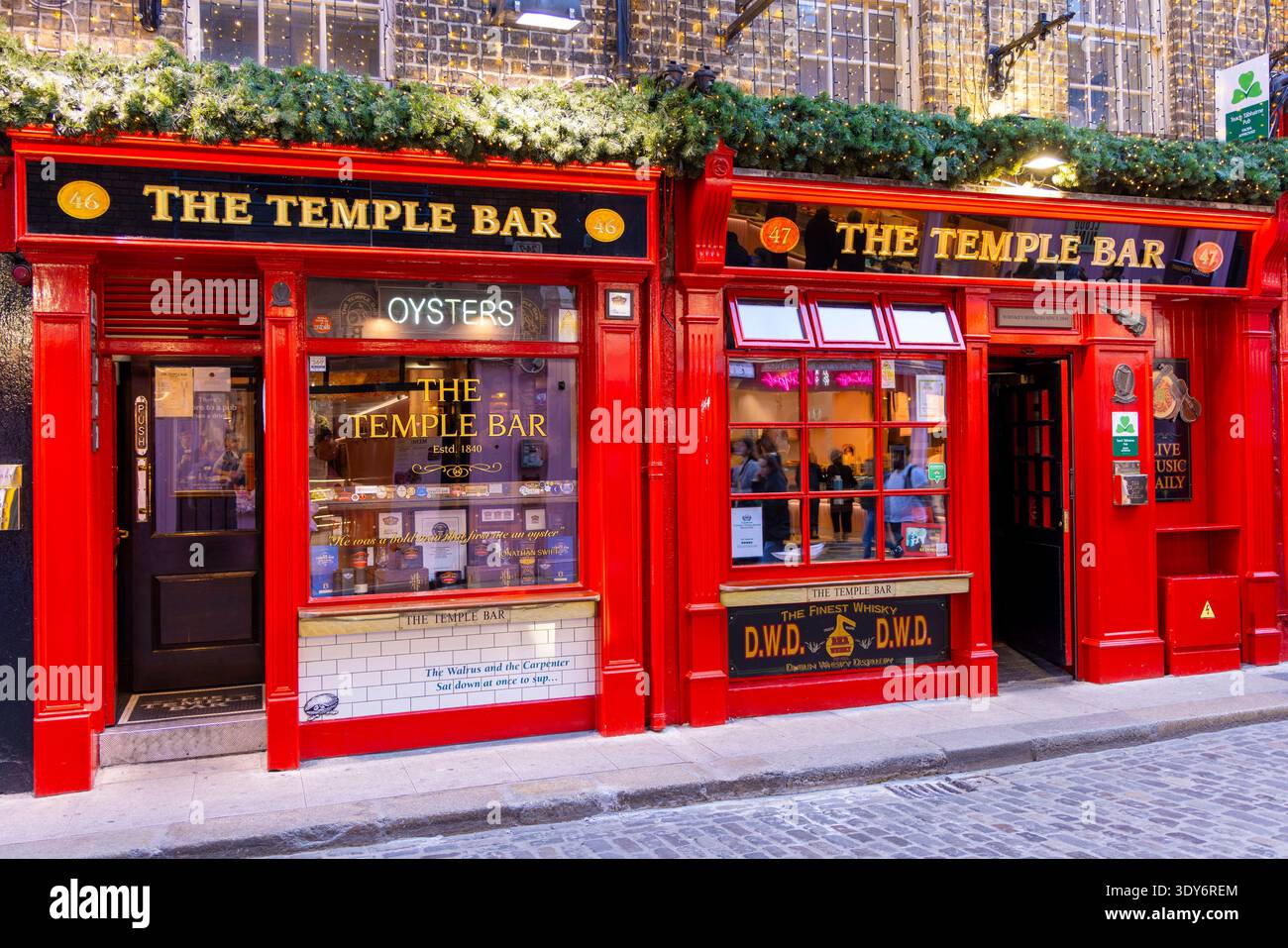 Les visiteurs apprécient des boissons et de la nourriture à l'extérieur devant le pub Temple Bar à Dublin, en Irlande, lors d'une soirée bien remplie Banque D'Images