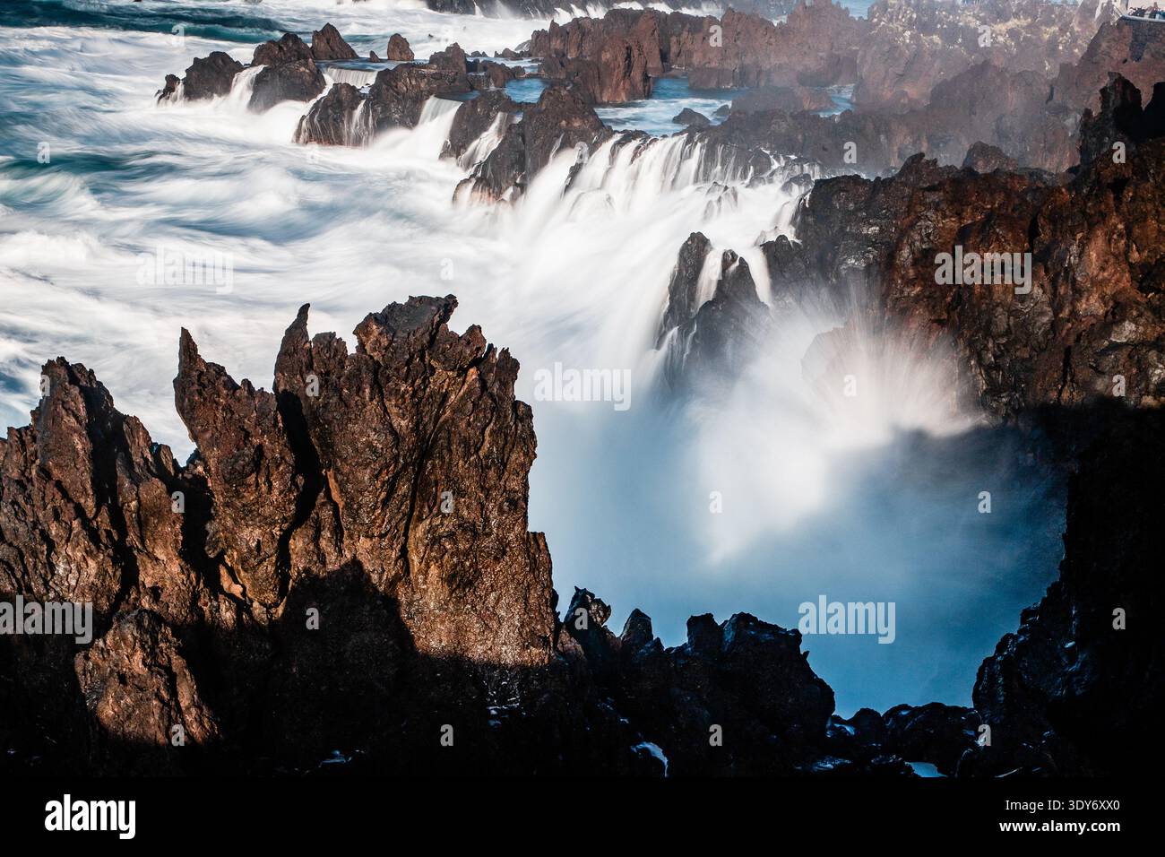 Les vagues s'écrasent contre les rives rocheuses à Porto Moniz Madère lors d'une puissante démonstration de la force de la nature par une journée ensoleillée Banque D'Images
