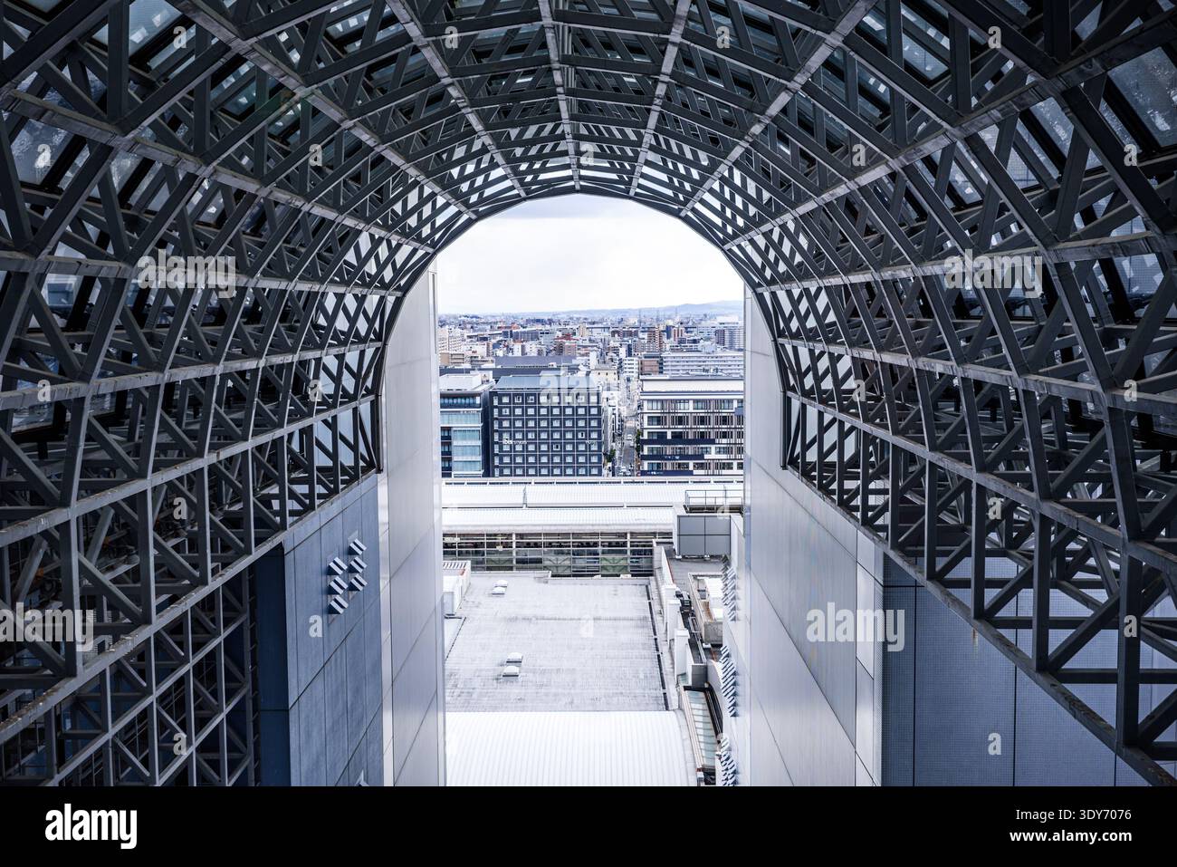 Le couloir futuriste en acier et verre de la gare de Kyoto offre une vue sur la ville à travers un cadre géométrique Banque D'Images