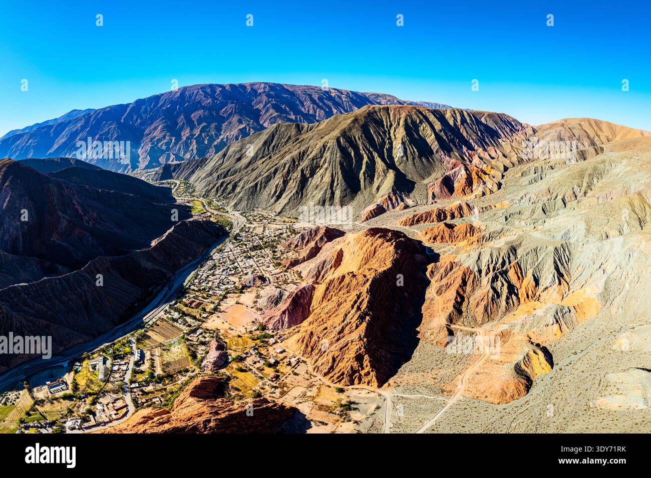 Vue panoramique sur le village de Purmamarca avec les montagnes environnantes en Argentine pendant la lumière du ciel clair Banque D'Images