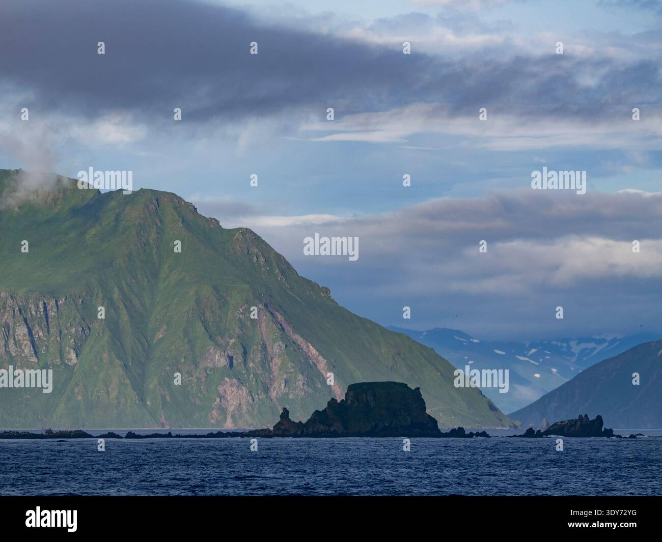 Vues de Rocky Baby Islands avec des montagnes en arrière-plan et des nuages dans le ciel en Alaska Banque D'Images