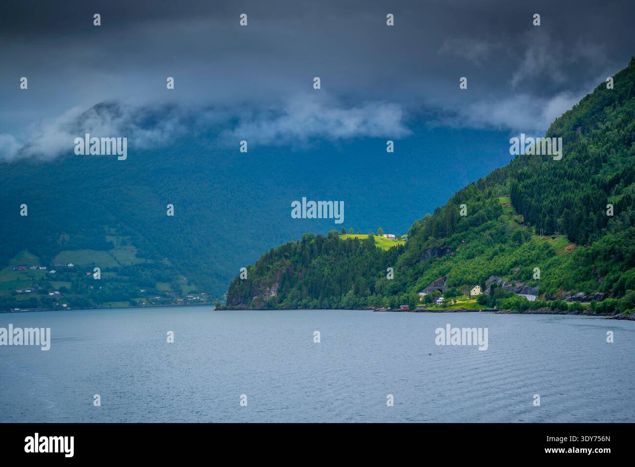 Vue de Nordfjorden depuis un bateau de croisière pendant l'été en Norvège avec des collines et des nuages en arrière-plan Banque D'Images