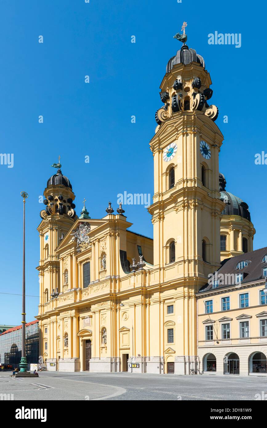 Façade principale et clochers de l'église baroque Theatinerkirche sur Odeonsplatz à Munich sous le soleil du matin Banque D'Images