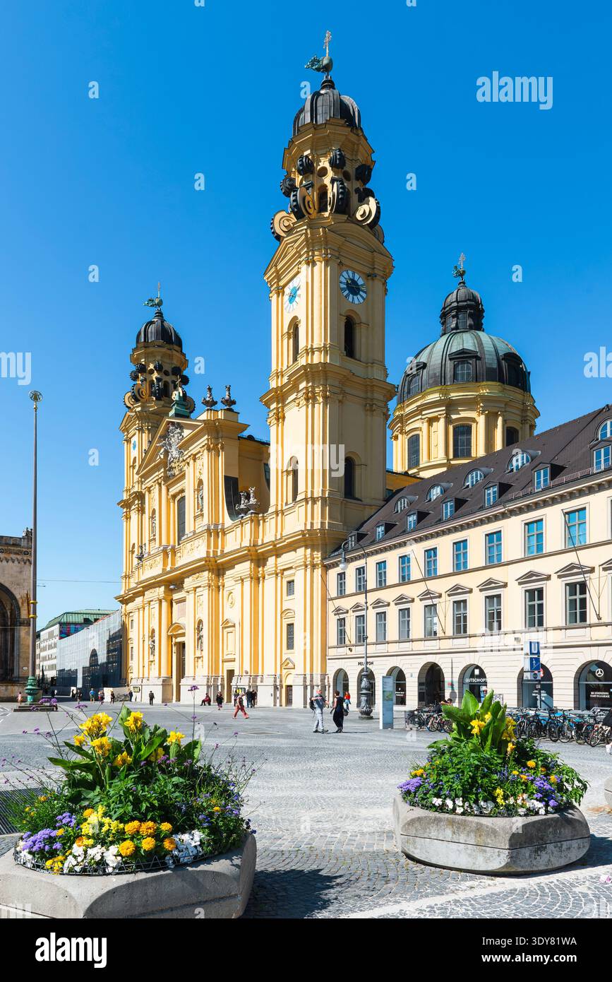 Façade principale et clochers de l'église baroque Theatinerkirche sur Odeonsplatz à Munich sous le soleil du matin Banque D'Images