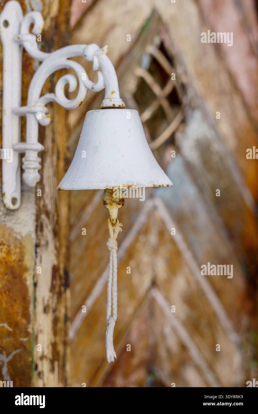 Cloche blanche pour un heurtoir de porte en bois rustique Banque D'Images