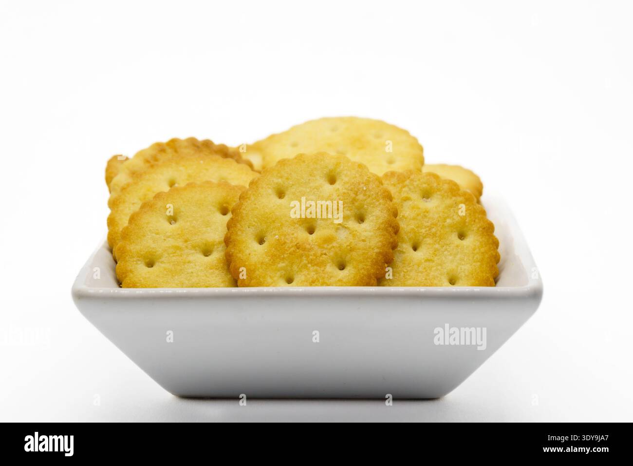 Bol avec des craquelins pour l'apéritif, isolé sur fond blanc. Banque D'Images