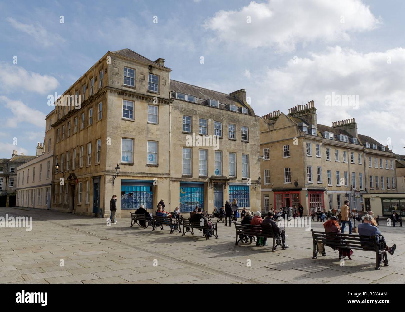 Les gens se relaxent sur des bancs à Kingston Parade dans le centre historique de Bath, Somerset, Angleterre, Royaume-Uni Banque D'Images