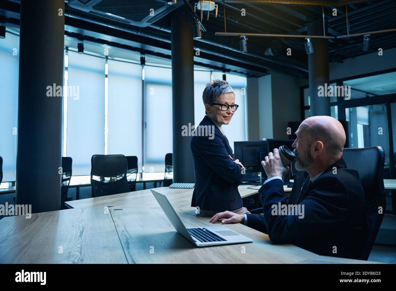 Deux adultes discutant des idées autour d'un café dans un bureau moderne Banque D'Images
