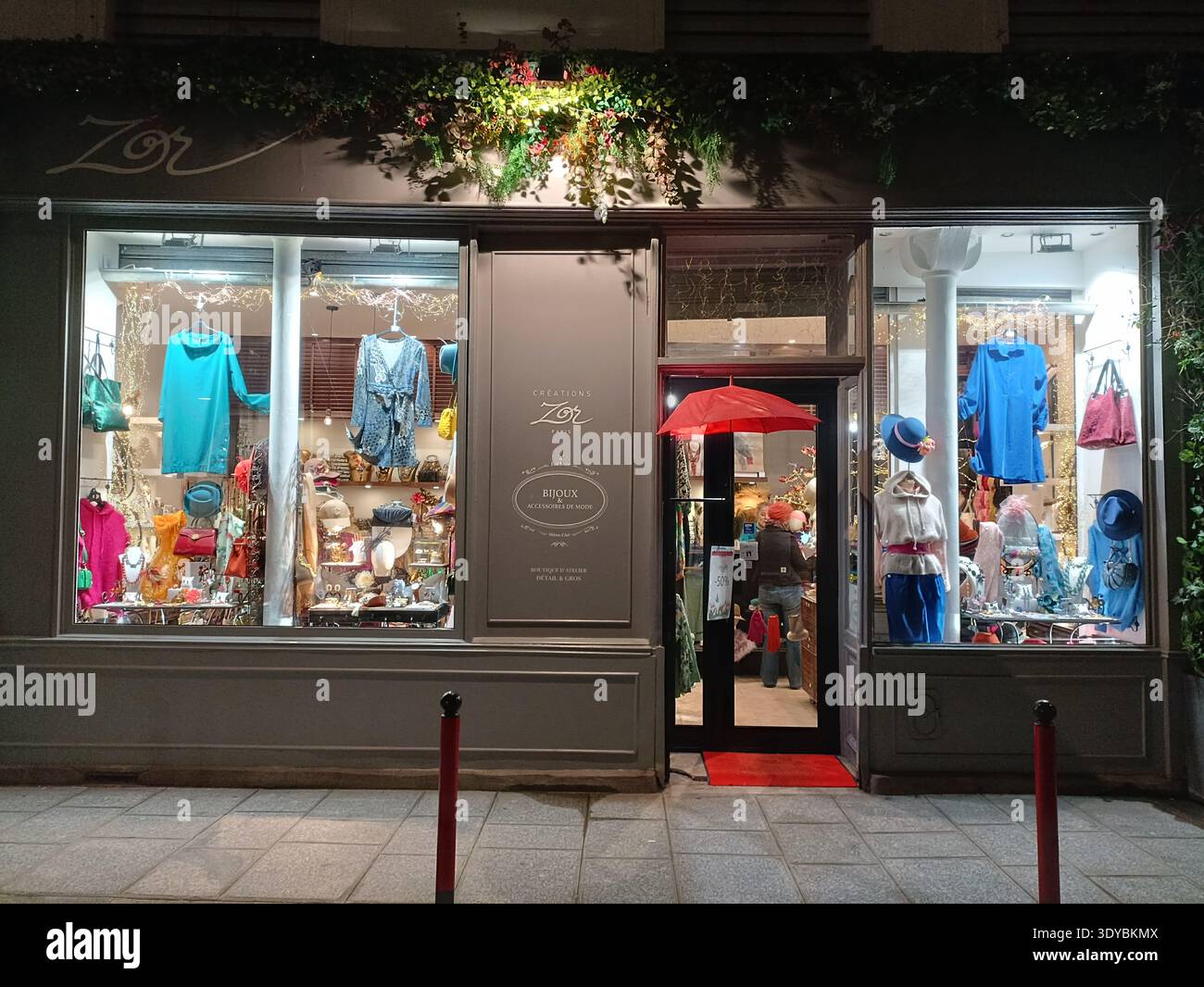 Boutique de mode illuminée la nuit sur la rue commerçante Rue d’Aboukir à Paris France Banque D'Images