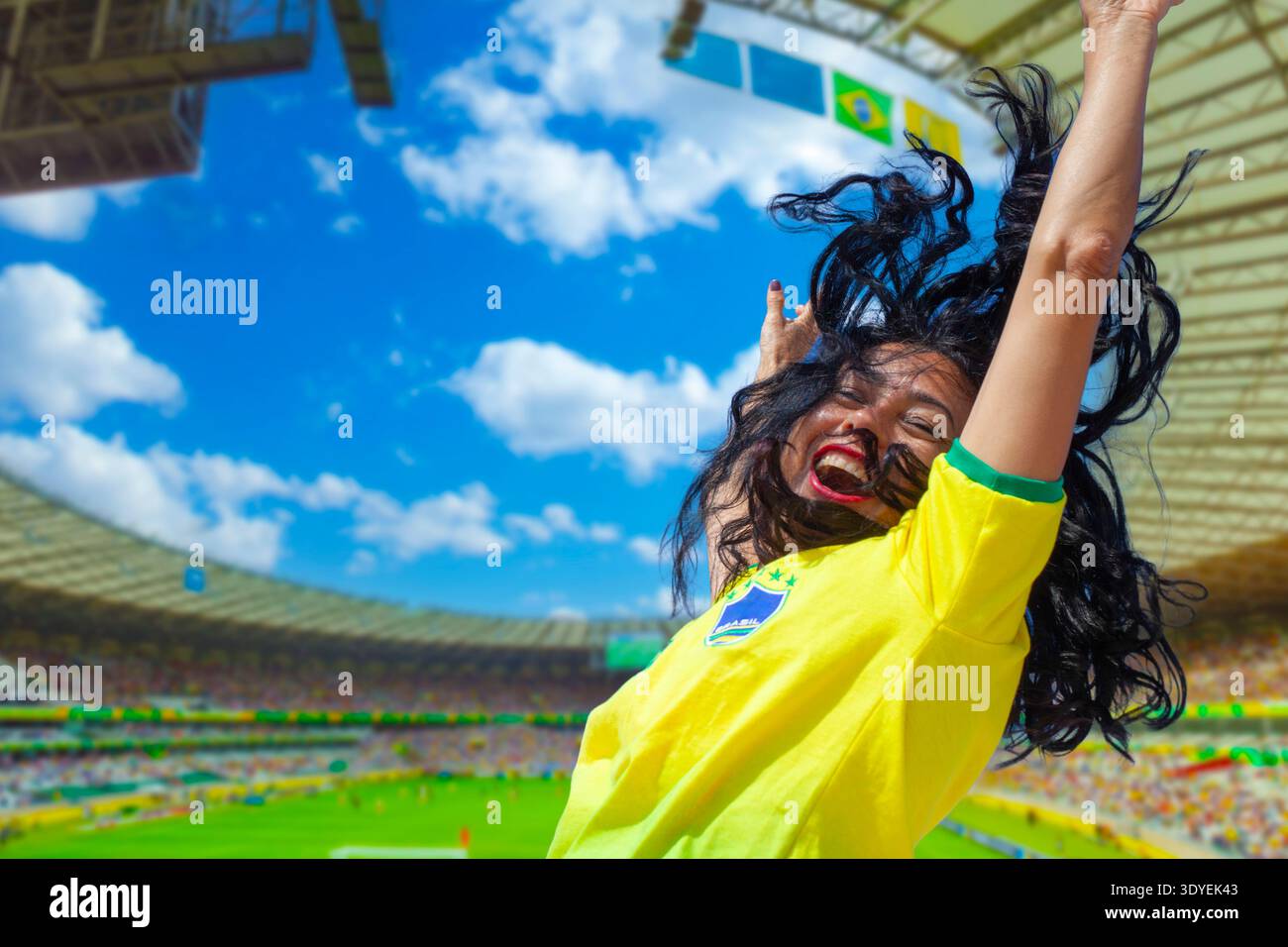 Passionnée de football brésilien célébrant une victoire au but dans un stade rempli sous un ciel bleu Banque D'Images