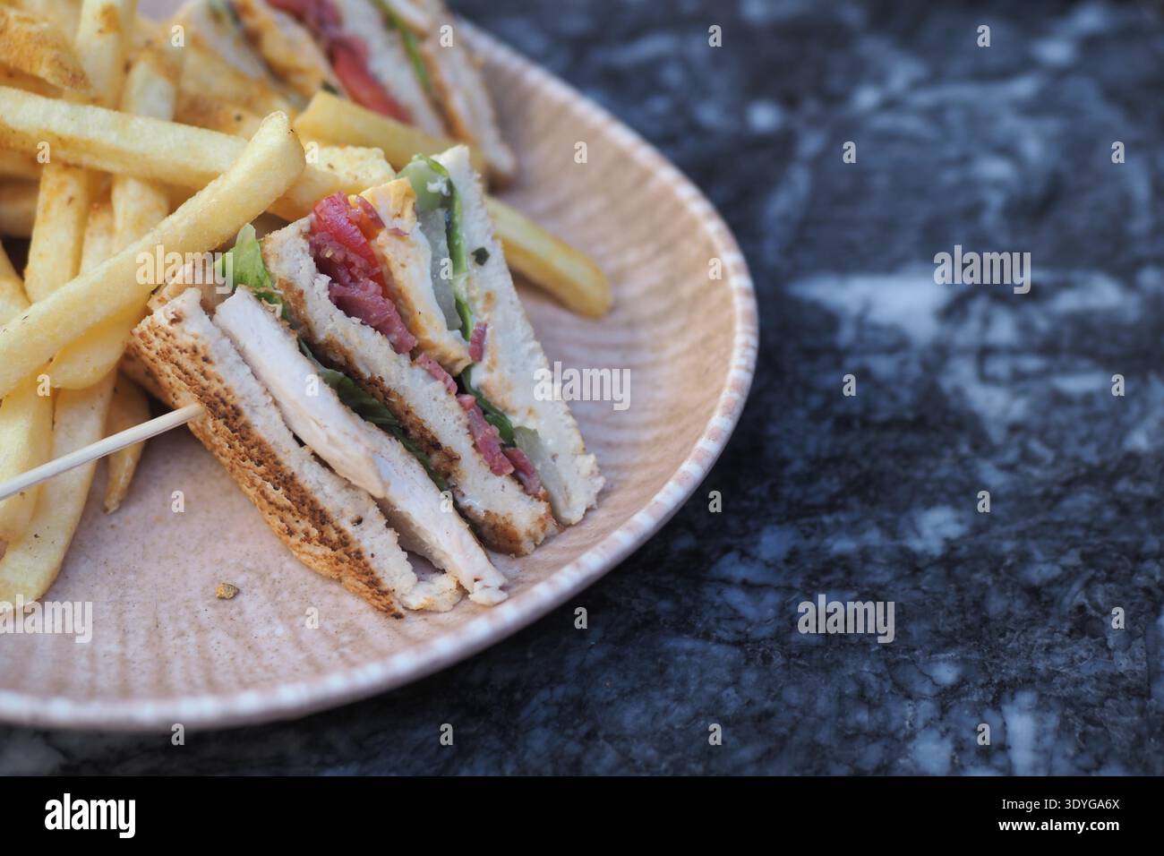Délicieux sandwich avec des frites sur une table à l'extérieur Banque D'Images