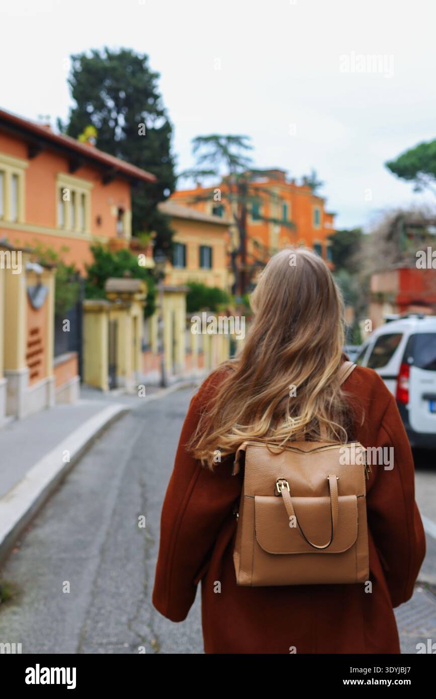 Jeune femme branchée profitant d'une promenade tranquille dans un vieux quartier européen à l'architecture vibrante. Banque D'Images