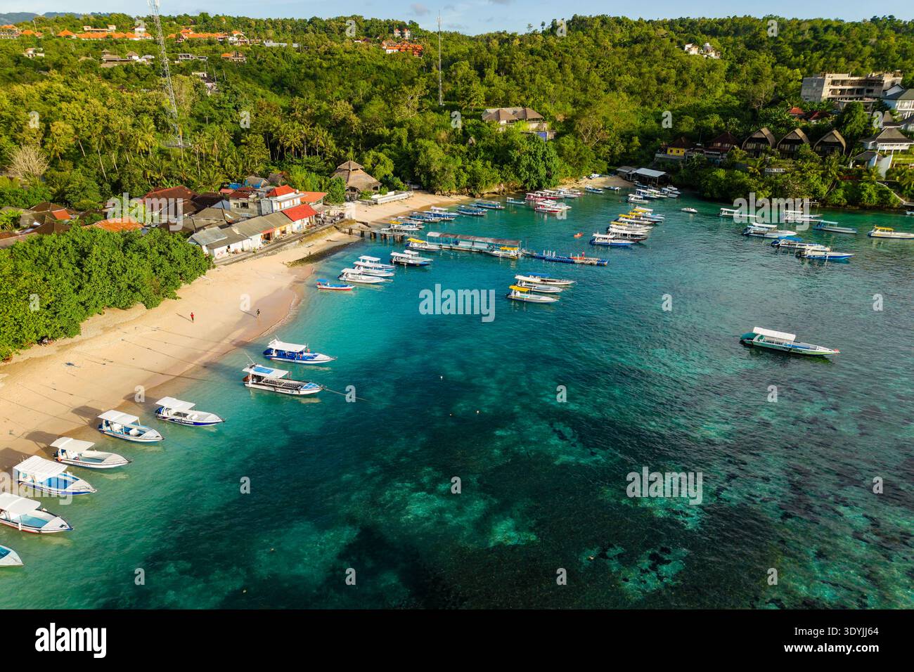 Vue aérienne des bateaux de tourisme amarrés dans une eau turquoise claire à Toyapakeh, Nusa Penida Banque D'Images