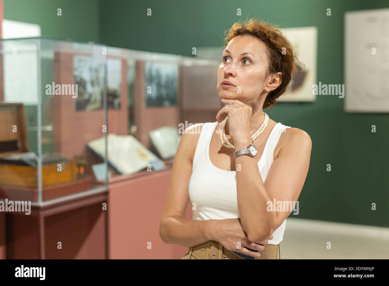 Femme d'âge moyen regardant les expositions dans le musée historique Banque D'Images