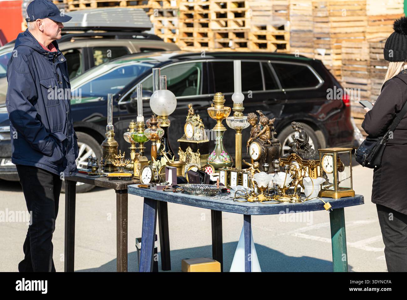 Horloges antiques, lampes vintage et objets décoratifs exposés à la vente sur table au marché aux puces en plein air en Pologne, marché aux puces d'Europe de l'est. Banque D'Images