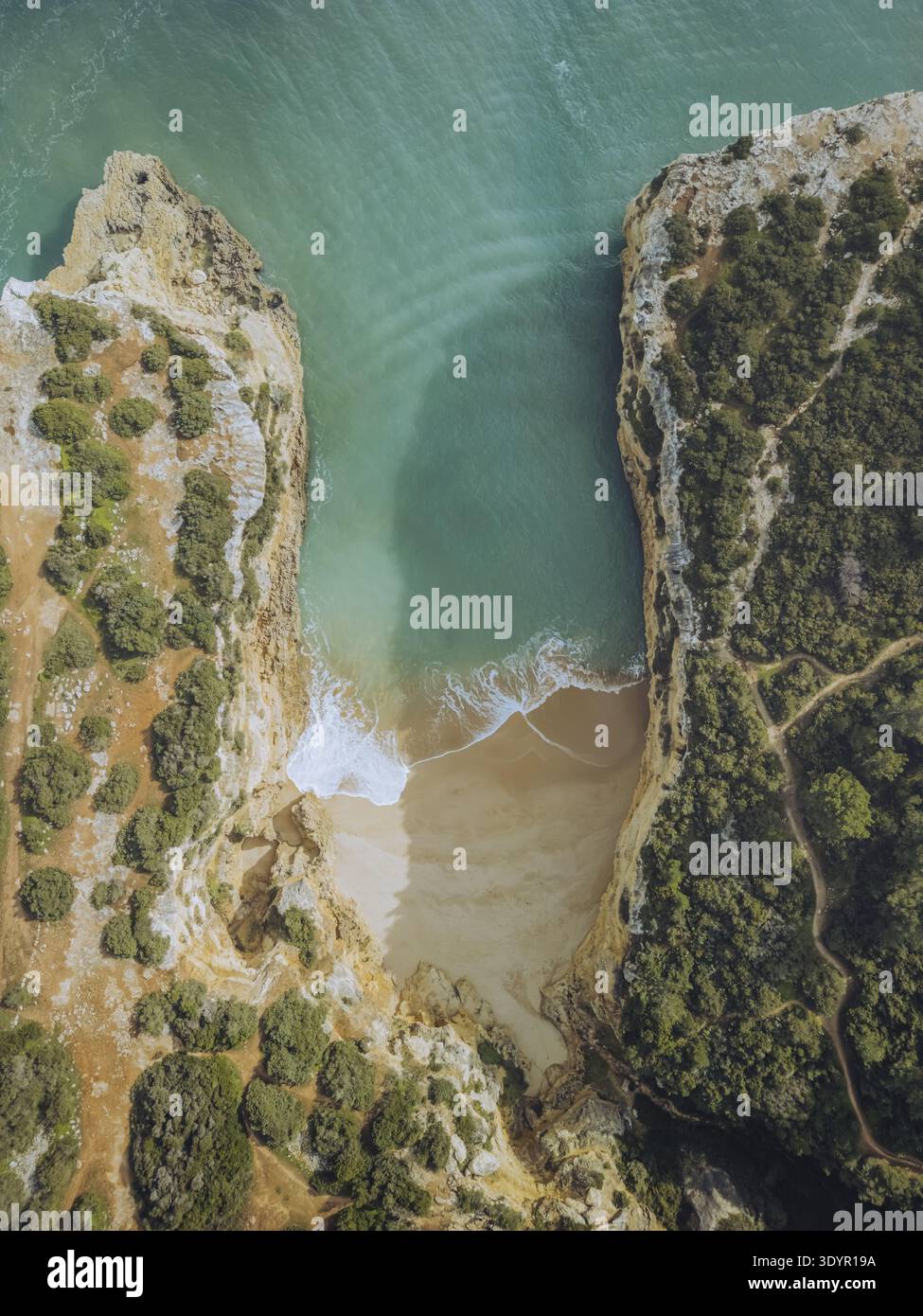 Vue aérienne de la plage isolée nichée entre des falaises escarpées, où les eaux turquoises rencontrent le sable doré dans une étreinte côtière magnifique, Porches, Faro Banque D'Images