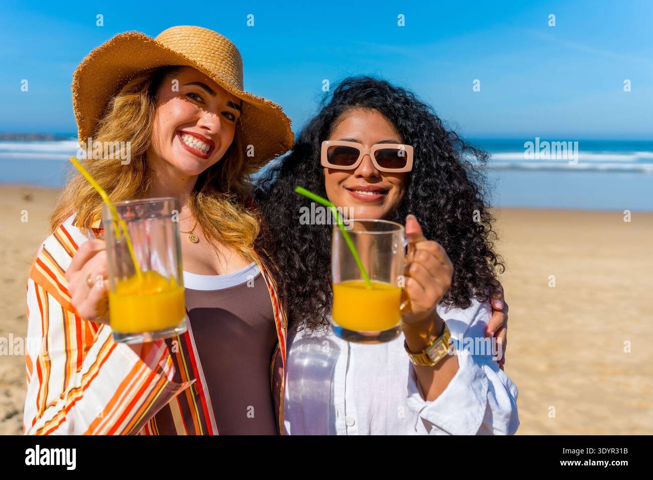 Heureux amis appréciant les vacances d'été boire du jus sur la plage Banque D'Images