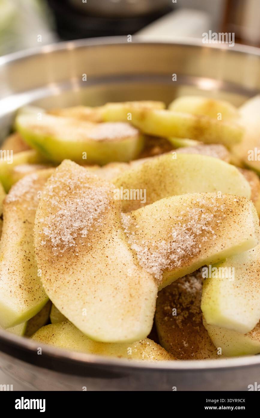 Bol de pommes tranchées enrobées de cannelle et de sucre pour tarte filli Banque D'Images