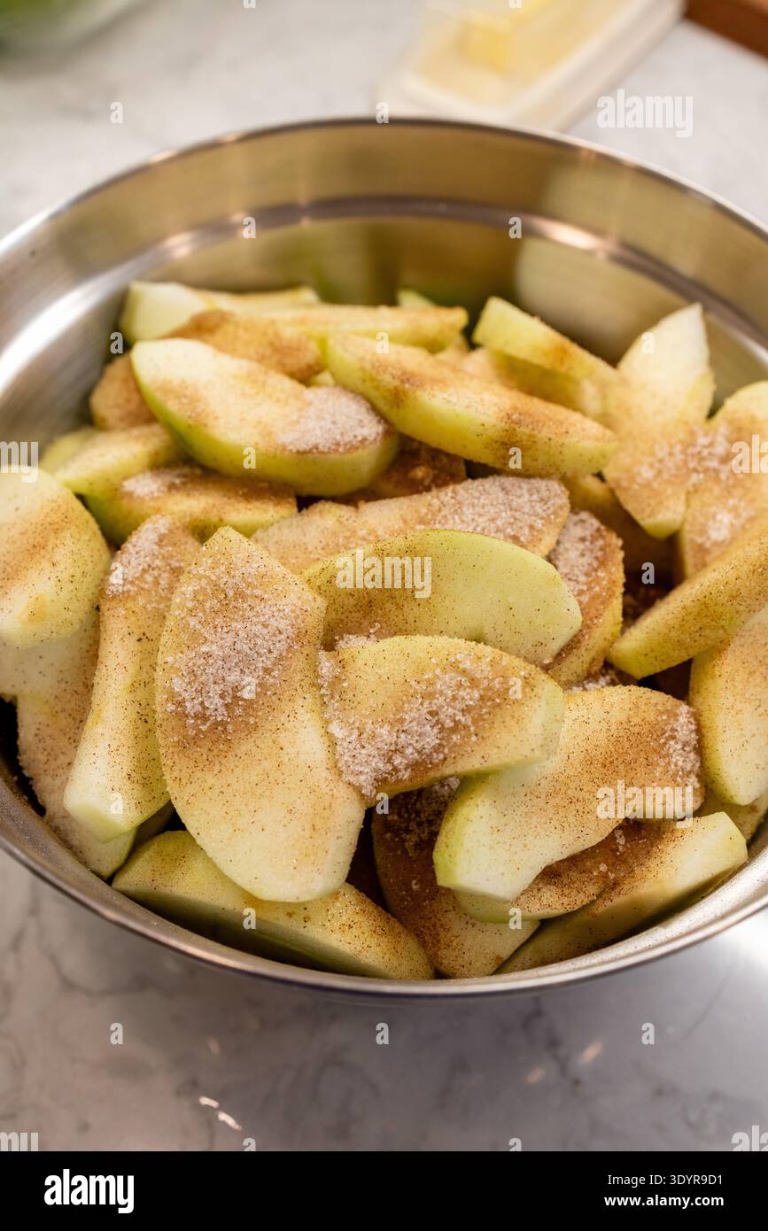 Bol de pommes tranchées enrobées de cannelle et de sucre pour tarte filli Banque D'Images