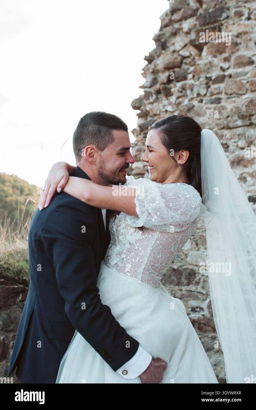 Marié soulevant et serrant la mariée. Banque D'Images