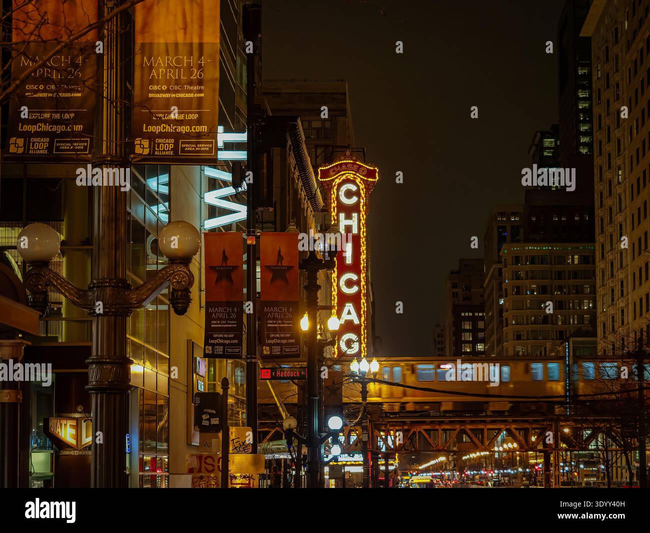 Le panneau emblématique du Chicago Theatre s'est illuminé la nuit au-dessus de Loop Street du centre-ville avec le passage d'un train surélevé Banque D'Images