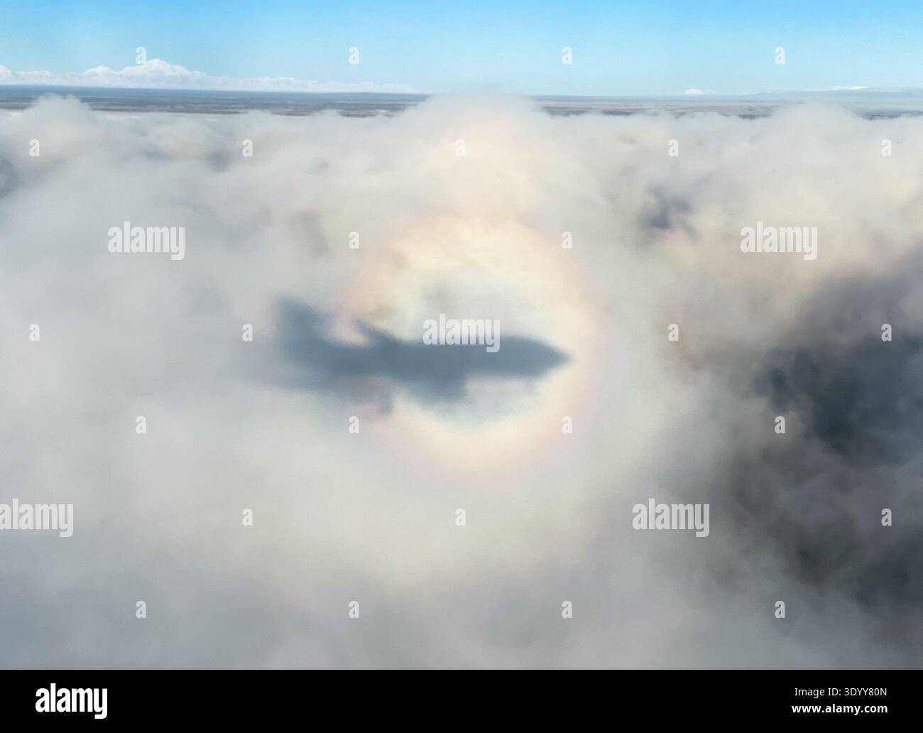 Ombre d'avion dans les nuages enhalée par un arc-en-ciel en cercle complet, avec Denali (précédent Mont McKinley) en arrière-plan - Image de stock capturée avec un smartphone