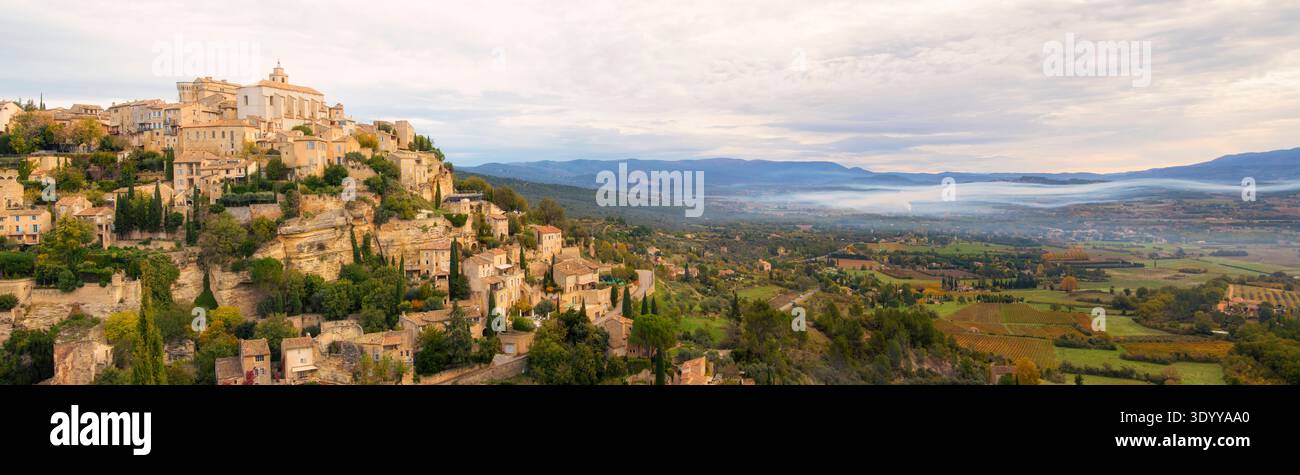 Gordes, France ; village perché avec de la fumée suspendue dans la vallée ci-dessous'Extrawide point panoramique Banque D'Images