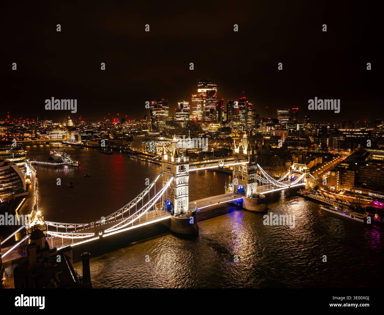 Vue aérienne du Tower Bridge illuminé et des gratte-ciel modernes qui se reflètent dans la Tamise la nuit, Londres, Grand Londres, Royaume-Uni Banque D'Images
