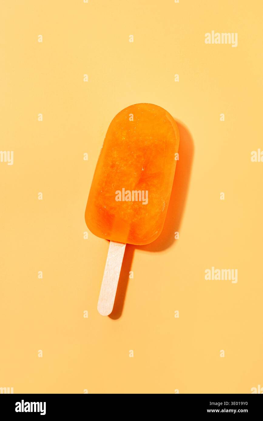 Crème glacée orange couchée sur un fond orange. Banque D'Images