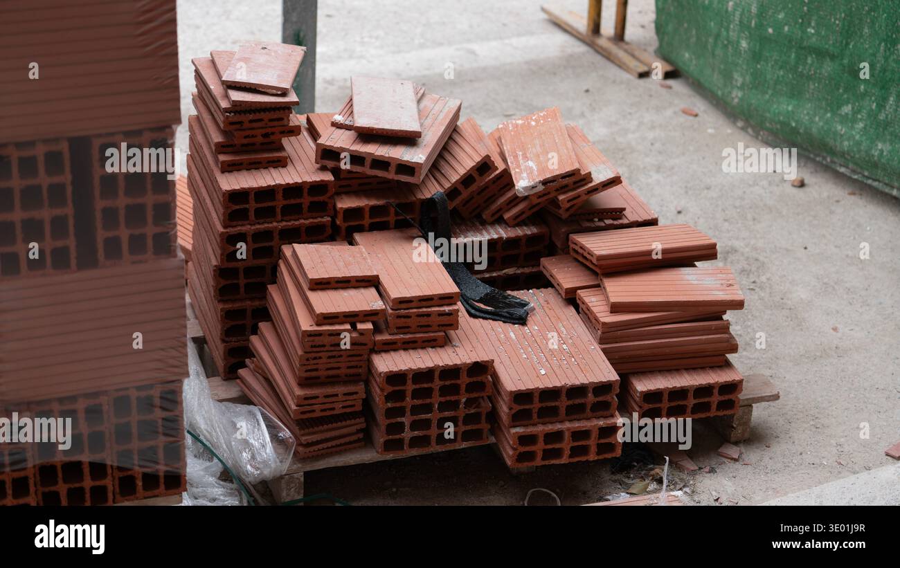 Pile de briques d'argile rouge sur le chantier de construction Banque D'Images