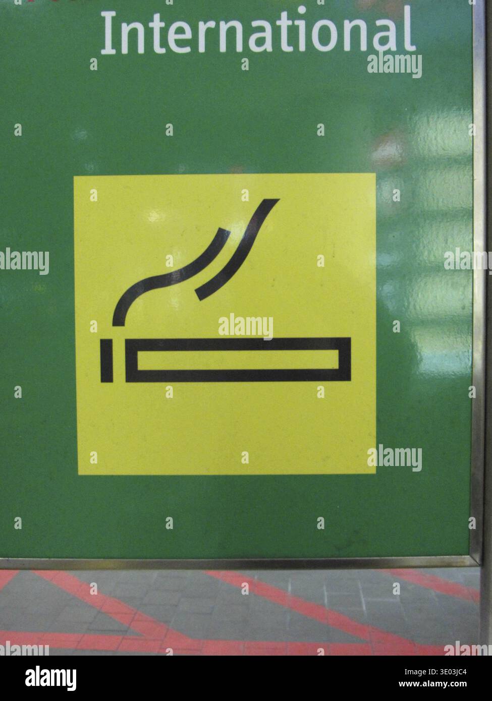 Signe jaune de zone fumeurs sur un fond vert, dans l'espace public Banque D'Images