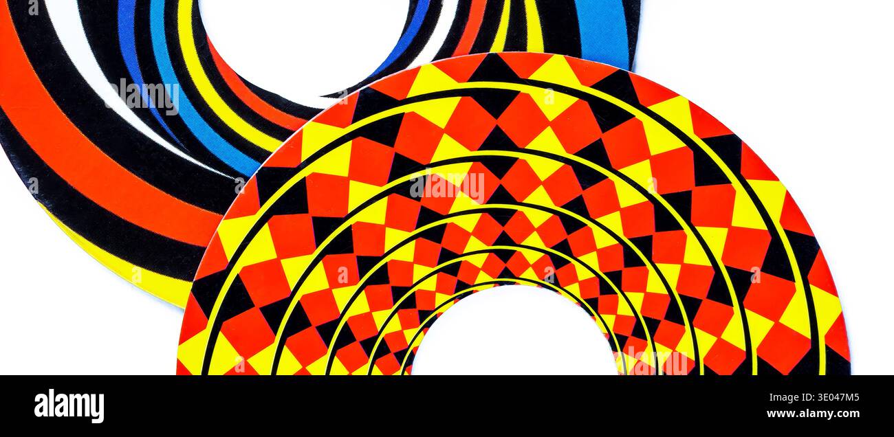 Disques d'illusion optique colorés avec des cercles concentriques et un motif géométrique de diamant, anneaux d'op art noir jaune rouge se chevauchant sur fond blanc, Banque D'Images