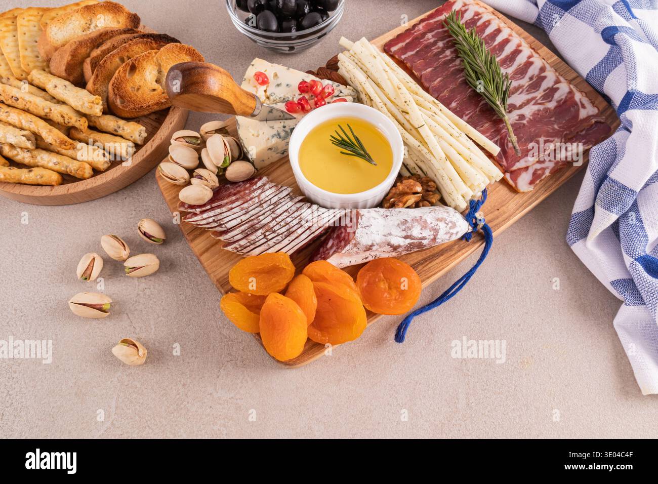 Un plateau de charcuterie gastronomique magnifiquement arrangé avec un assortiment de fromages, charcuteries, fruits secs, noix et olives. Parfait pour élégant Banque D'Images