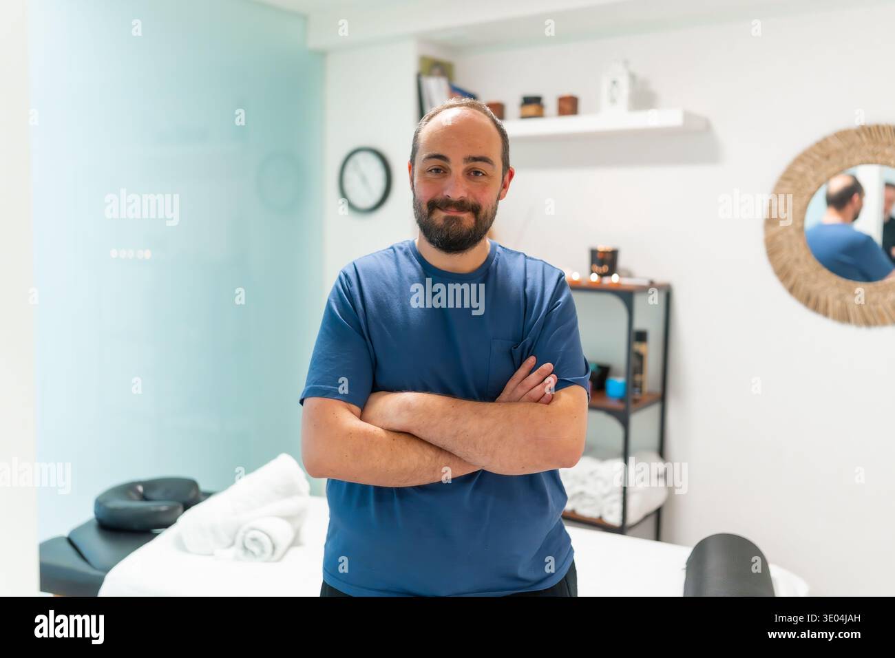 Massothérapeute masculin souriant dans la clinique de spa Banque D'Images