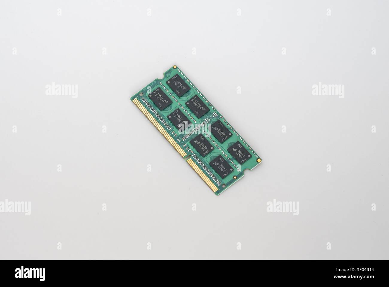 Circuit imprimé vert avec puces noires et contacts dorés, isolé sur blanc. Composant matériel informatique pour le traitement de données. Banque D'Images