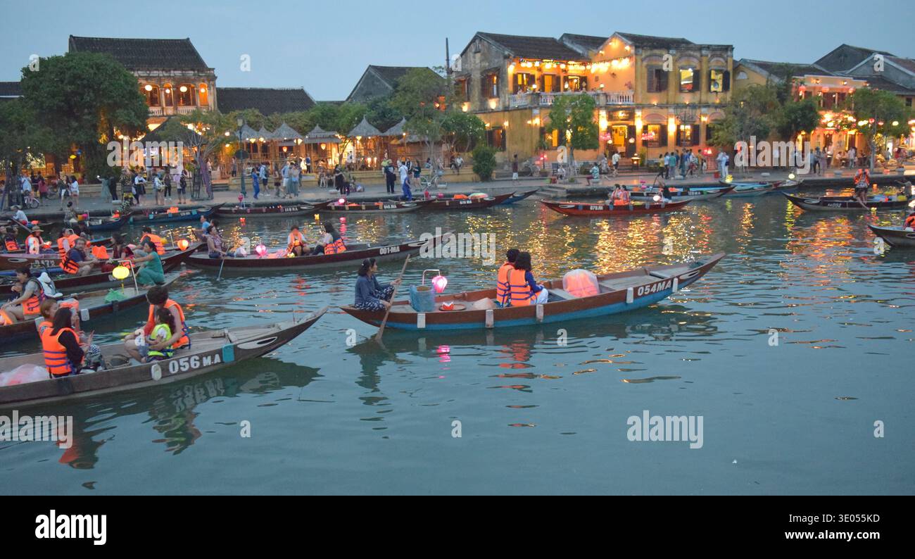 Vietnam Hoi une ville romantique avec des touristes dans des bateaux lançant des lanternes allumées. Banque D'Images