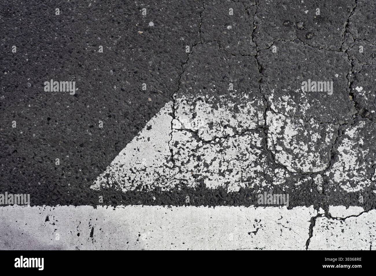 Texture urbaine de surface de route fissurée et marques peintes en blanc vieilli Banque D'Images