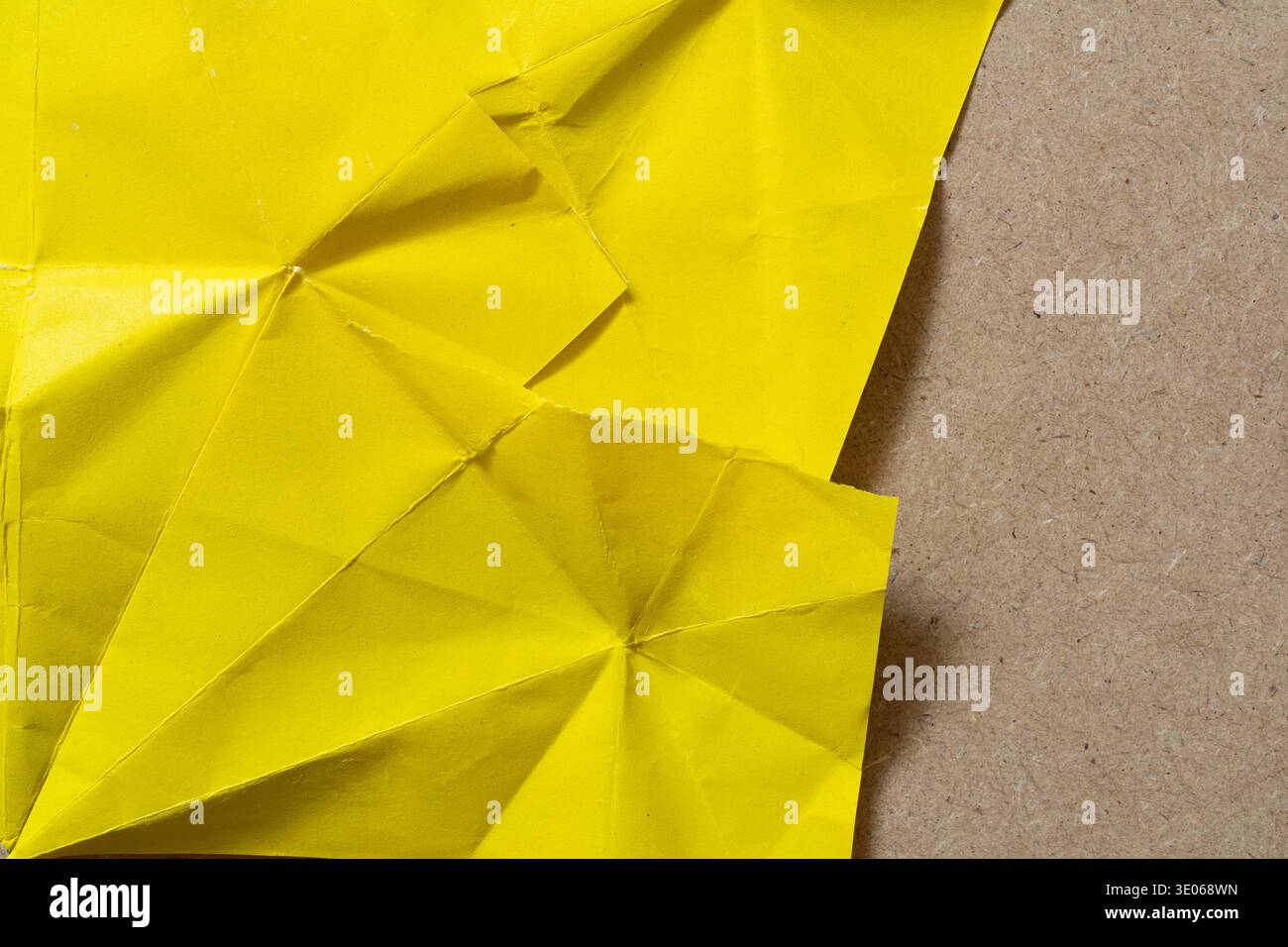 Composition minimaliste de feuille jaune pliée et de fond de contreplaqué simple Banque D'Images
